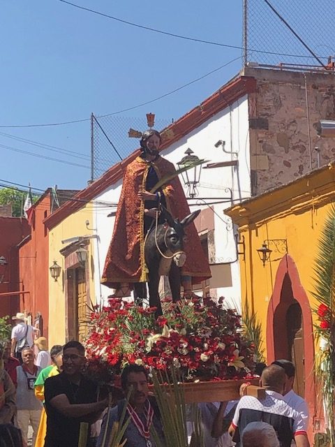 The highlight of the procession was Jesus atop a donkey surrounded by red and white flowers symbolizing happiness.