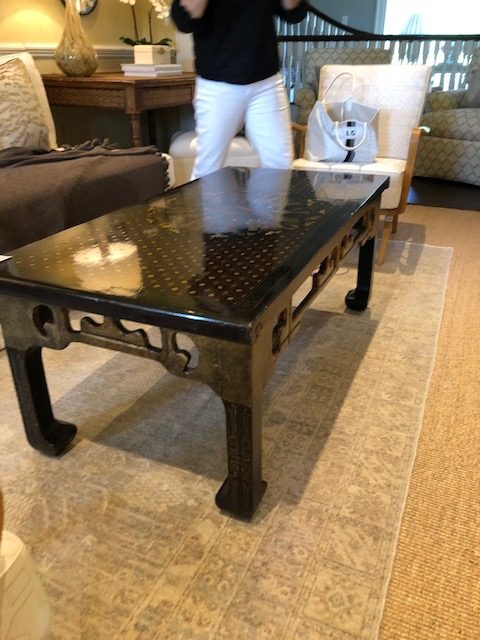 My friend excitedly stands behind her new table.